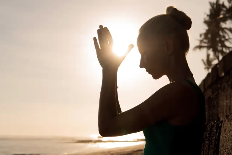 Frau meditiert am Strand